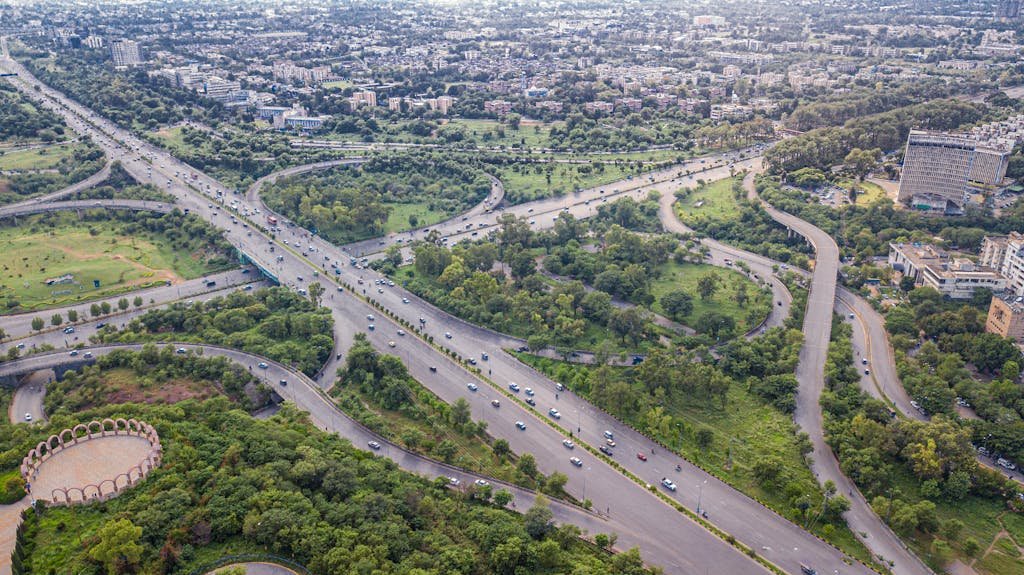 Aerial shot of Islamabad's intricate expressway system, showcasing lush greenery and urban development.
