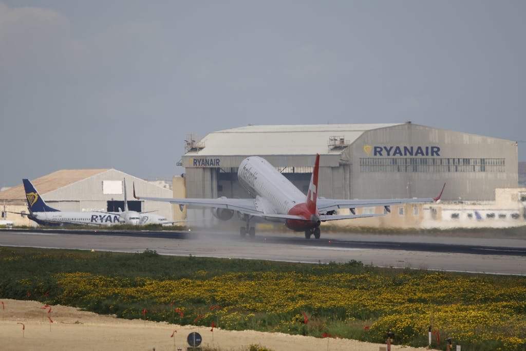 Airplanes near Ryanair hangar, takeoff at airstrip. Aviation scene.