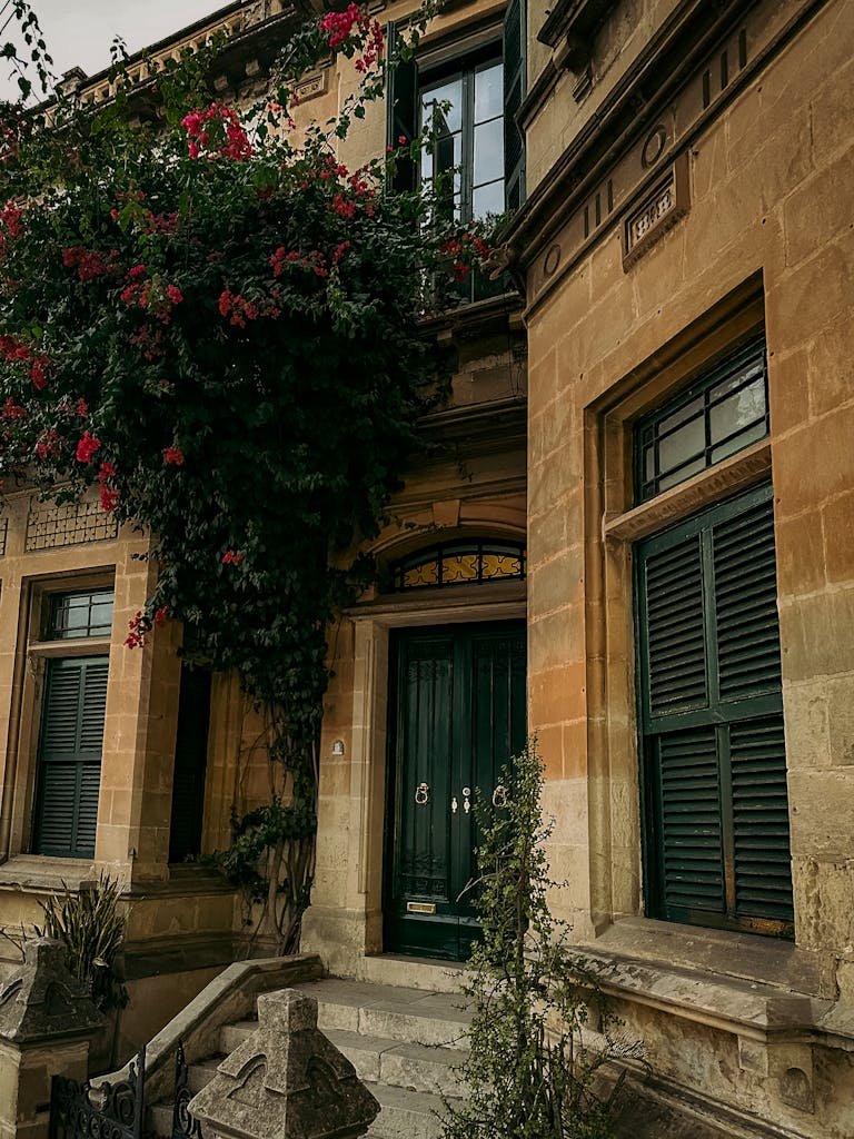 21 Best things to do in Mdina, Malta's Silent City 6 An inviting facade of a historic Maltese house adorned with lush bougainvillea.