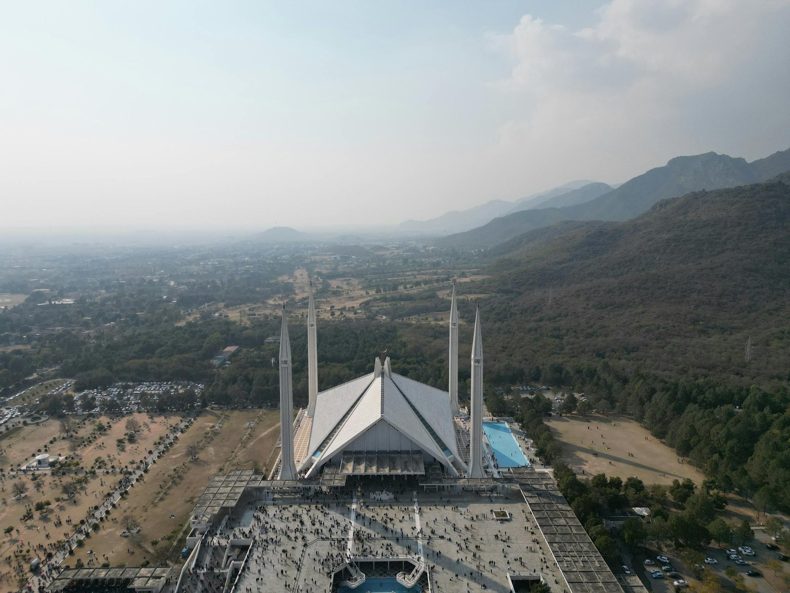 Bird's-eye view of the iconic Faisal Mosque with distant landscape in Islamabad, Pakistan.