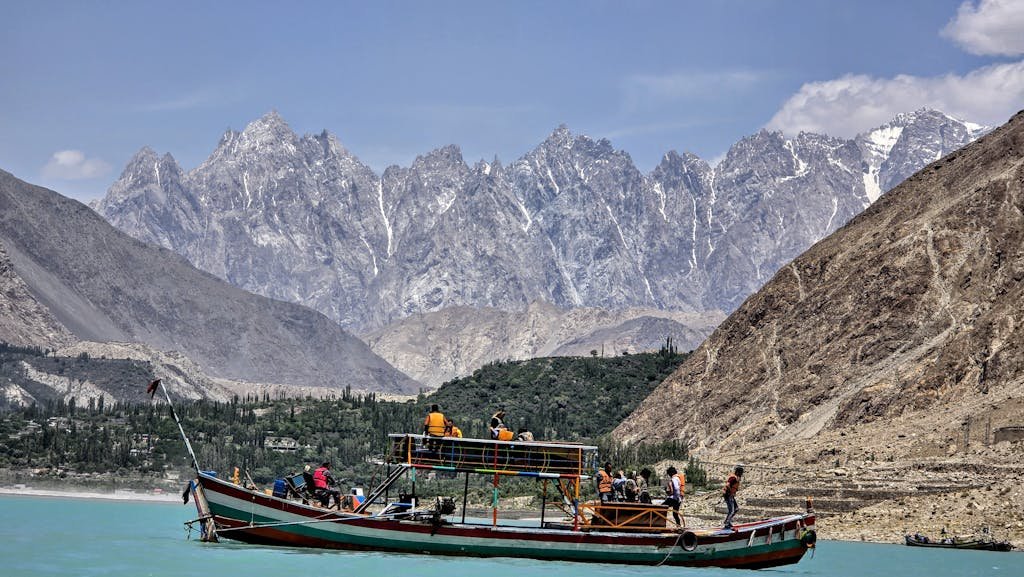 Experience the breathtaking landscapes of Hunza Nagar with a scenic boat ride under majestic mountain peaks.