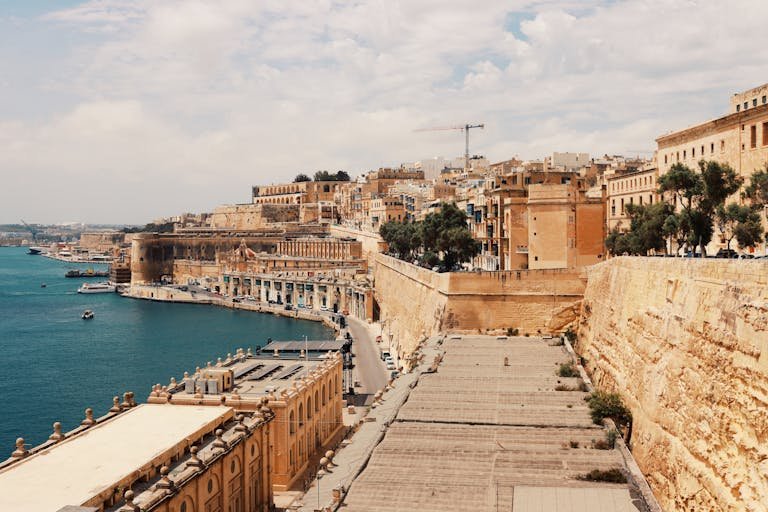 Explore Valletta's stunning waterfront with historic architecture and the serene harbor view.