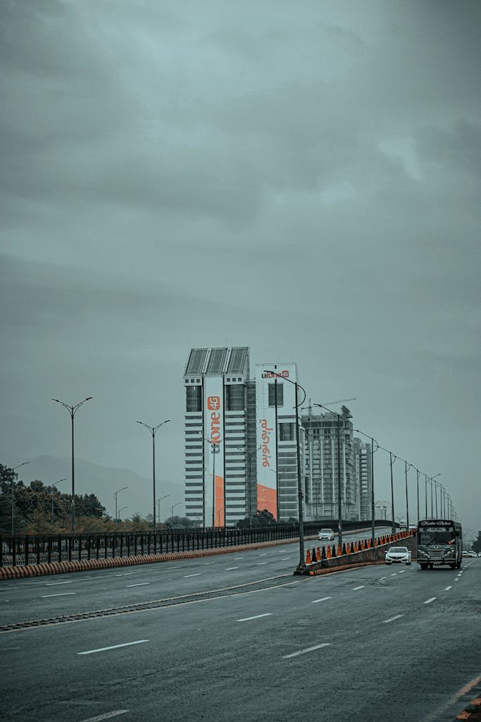 Overcast view of Islamabad highway showing tall buildings and traffic.