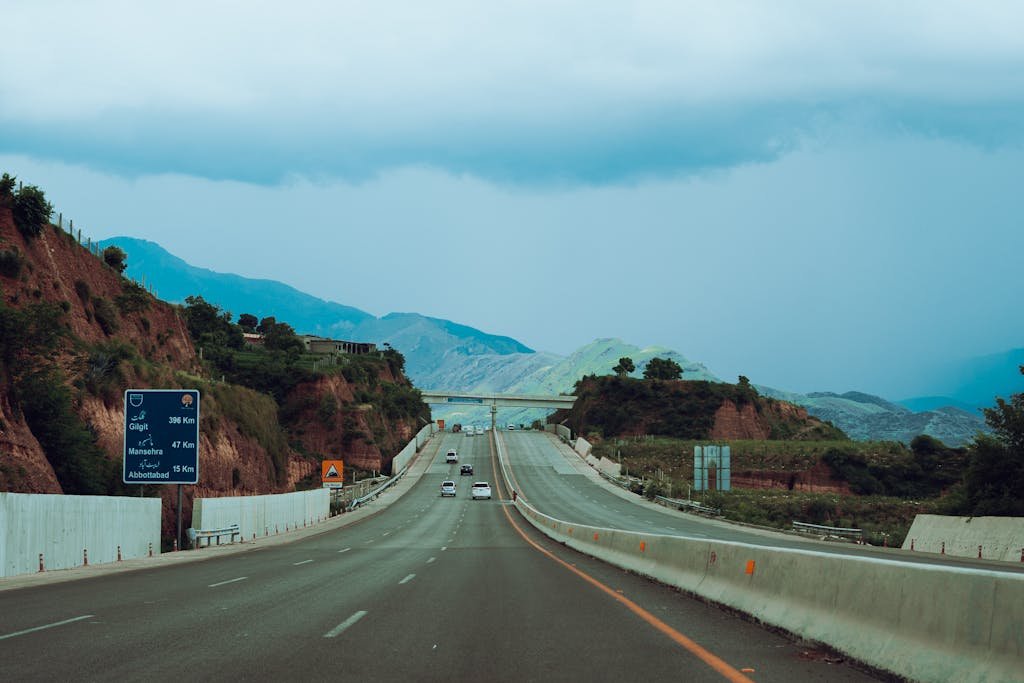 Picturesque highway road with distant mountains and cloudy sky in Pakistan.