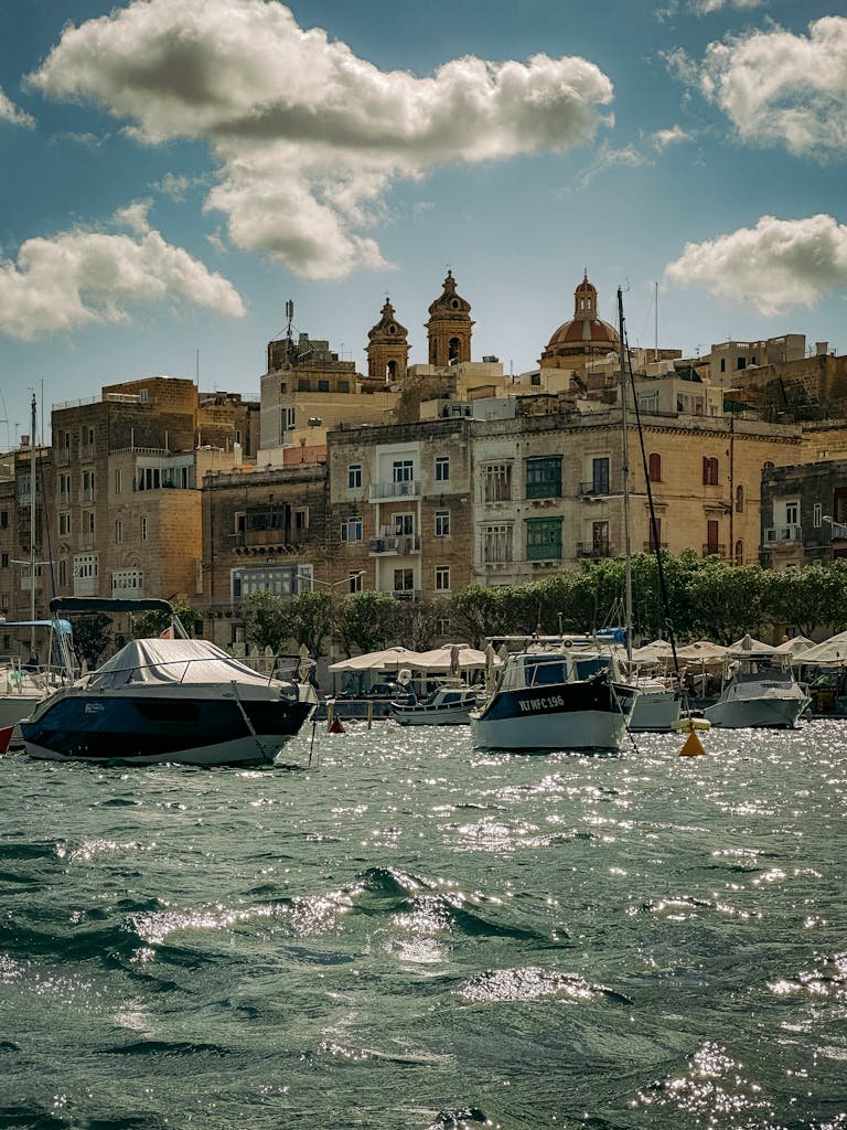 Picturesque waterfront with boats and historic architecture in Valletta, Malta.