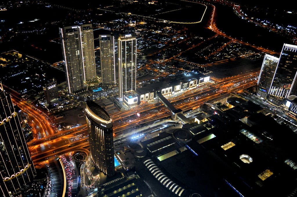 Stunning aerial view of illuminated skyscrapers and roads in Dubai at night.