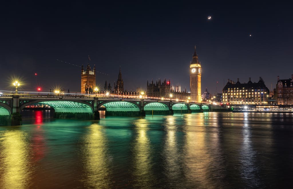 Stunning night scene of Big Ben and Westminster Bridge in London, reflected in the Thames.