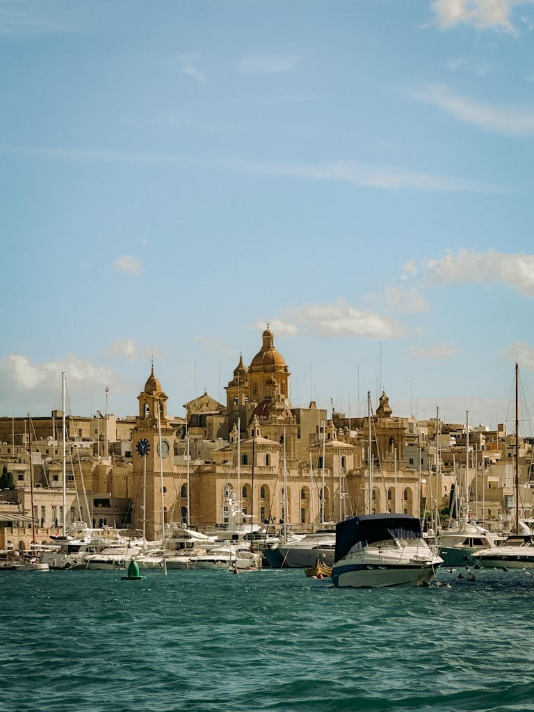 Stunning view of Valletta's skyline with historic churches and marina, under bright blue skies.