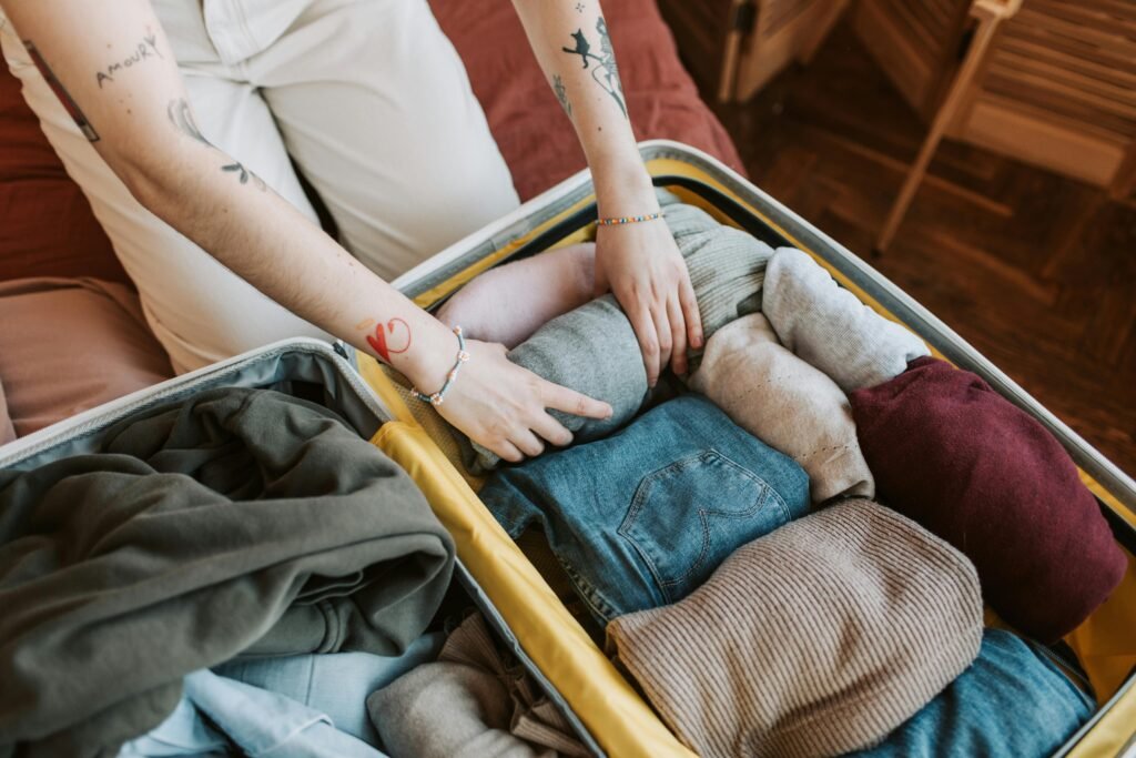 woman putting folded clothes in suitcas following  what to pack for Europe trip list
