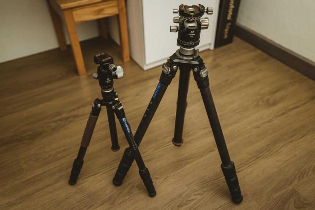 Two black tripods standing on wooden floor
