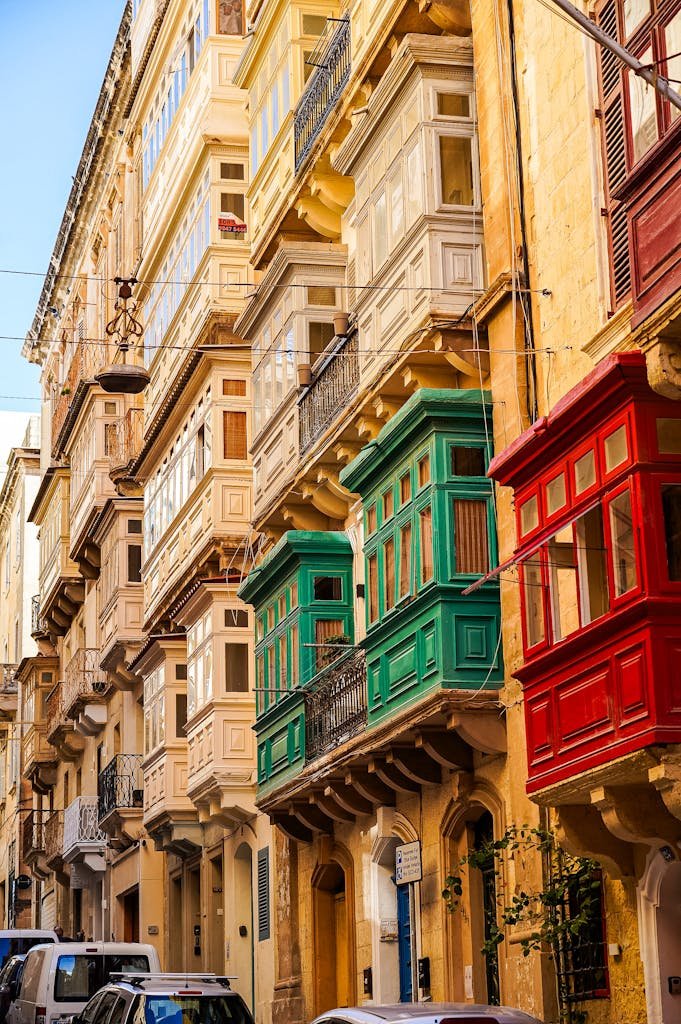Vibrant historic balconies in a street of Valletta, showcasing Maltese architecture.