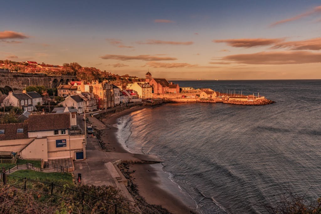 A beautiful sunset view of Kinghorn's coastal townscape along the Firth of Forth, Scotland.