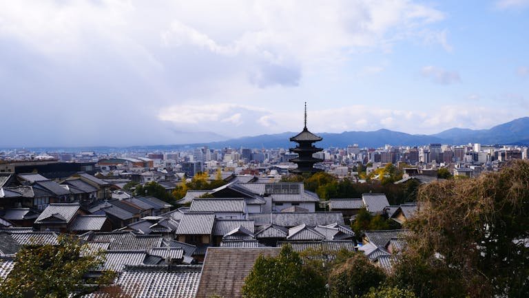 A breathtaking view of Kyoto city with traditional pagoda and modern skyline.