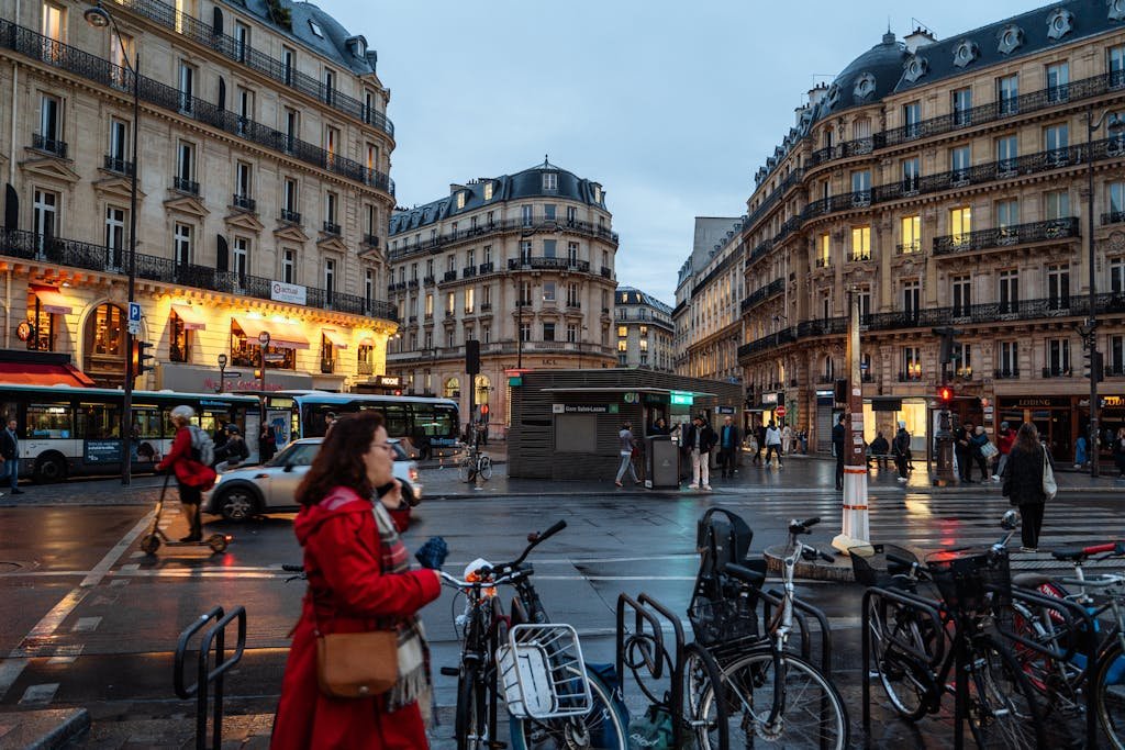 A busy Paris street intersection at twilight with elegant architecture and vibrant city life.