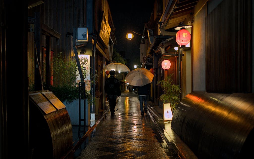 14 Best Things to Do in Kyoto, Japan + Travel Tips (2026) 14 A serene nighttime scene in Kyoto's Pontocho alleyway, illuminated by traditional lanterns and a light rain.