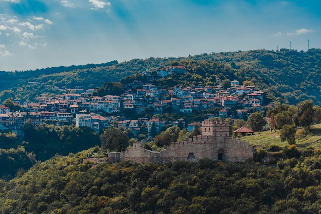 A stunning aerial view of Veliko Tarnovo, Bulgaria, showcasing a historic fortress and vibrant hillside houses.