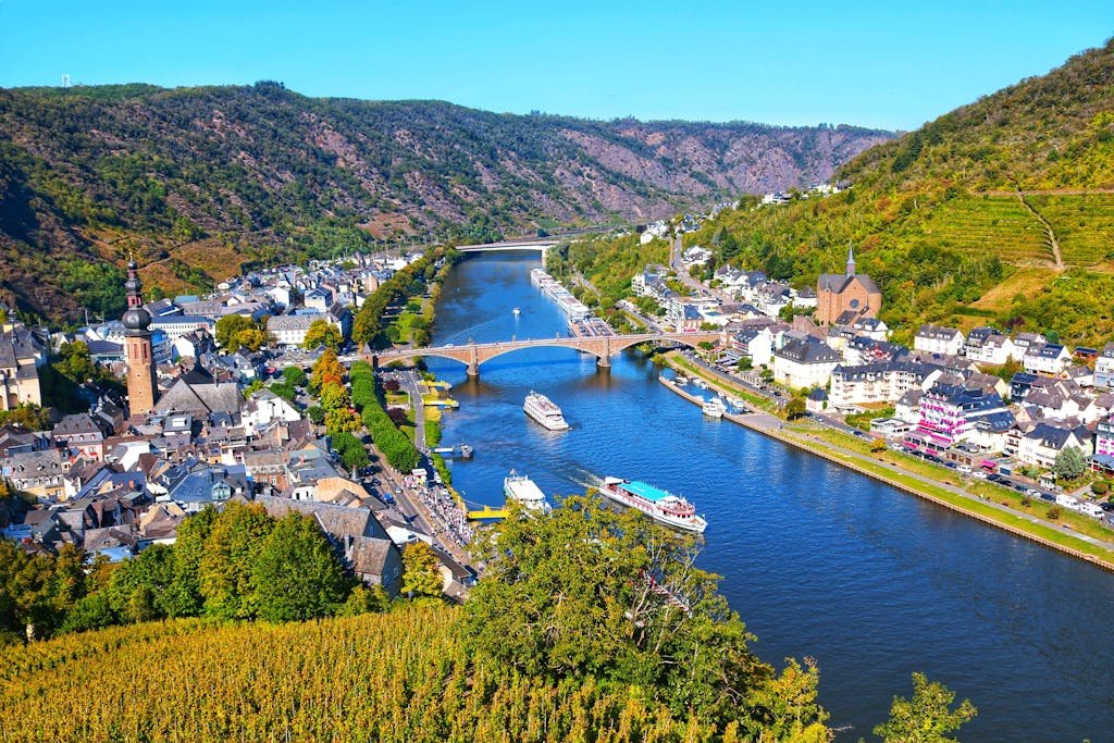 Aerial view of Cochem, Germany with the Moselle River, boats, and lush vineyards seen as the best road trip routes in Europe