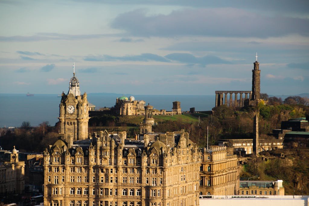 Aerial view of Edinburgh featuring The Balmoral Hotel and historic Calton Hill landmarks.