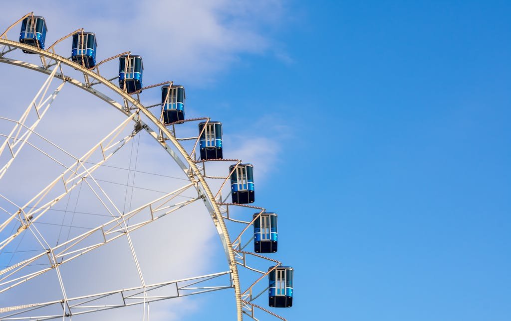 Bright ferris wheel cabins set against a vibrant blue sky in Stuttgart, Germany.