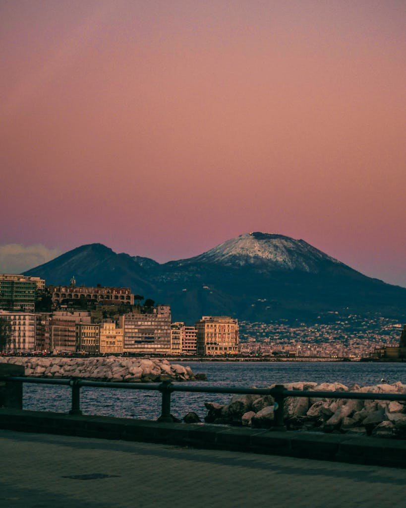 Captivating view of Mount Vesuvius and Naples at sunset, showcasing the iconic Italian landscape seen on a budget trip to naples
