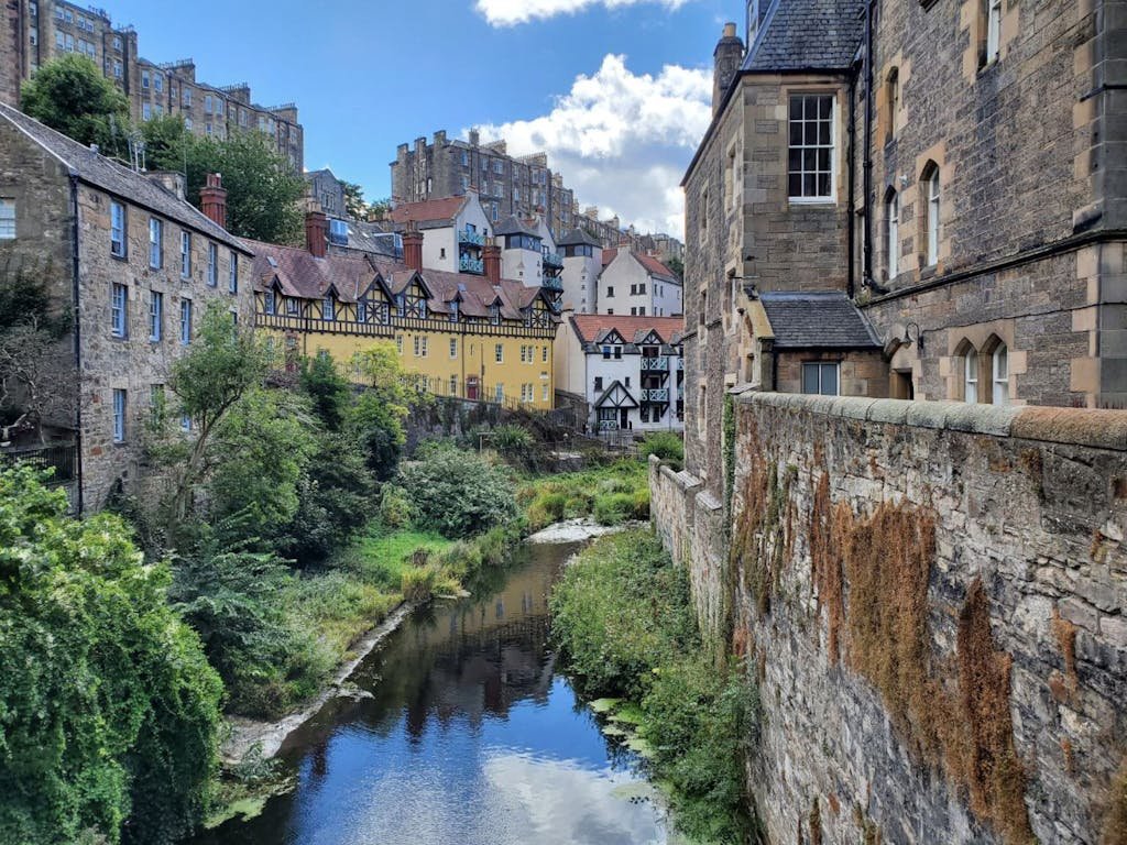 Charming view of historic buildings in Dean Village, Edinburgh, reflected in the Water of Leith.