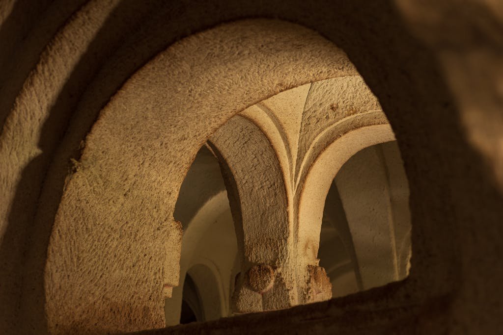 Close-up view of historical stone archways with intricate designs in warm light.