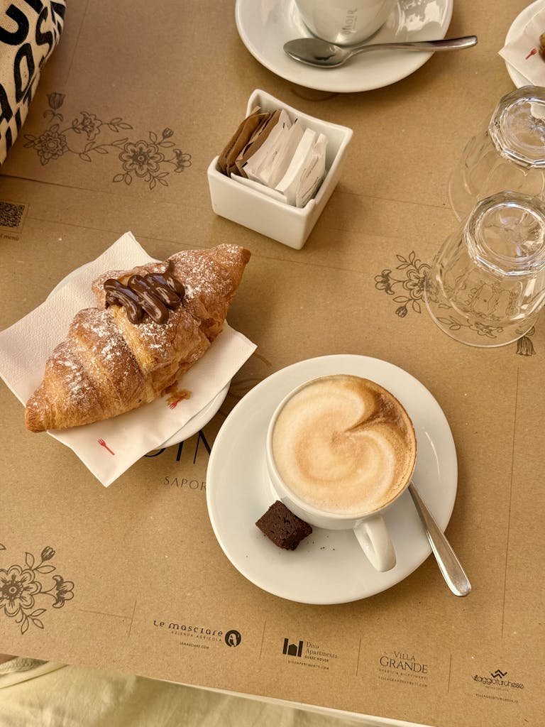 Is Naples Worth Visiting? 15 Pros and 5 Cons 9 Cozy morning setup with cappuccino and chocolate croissant, perfect start to the day.
