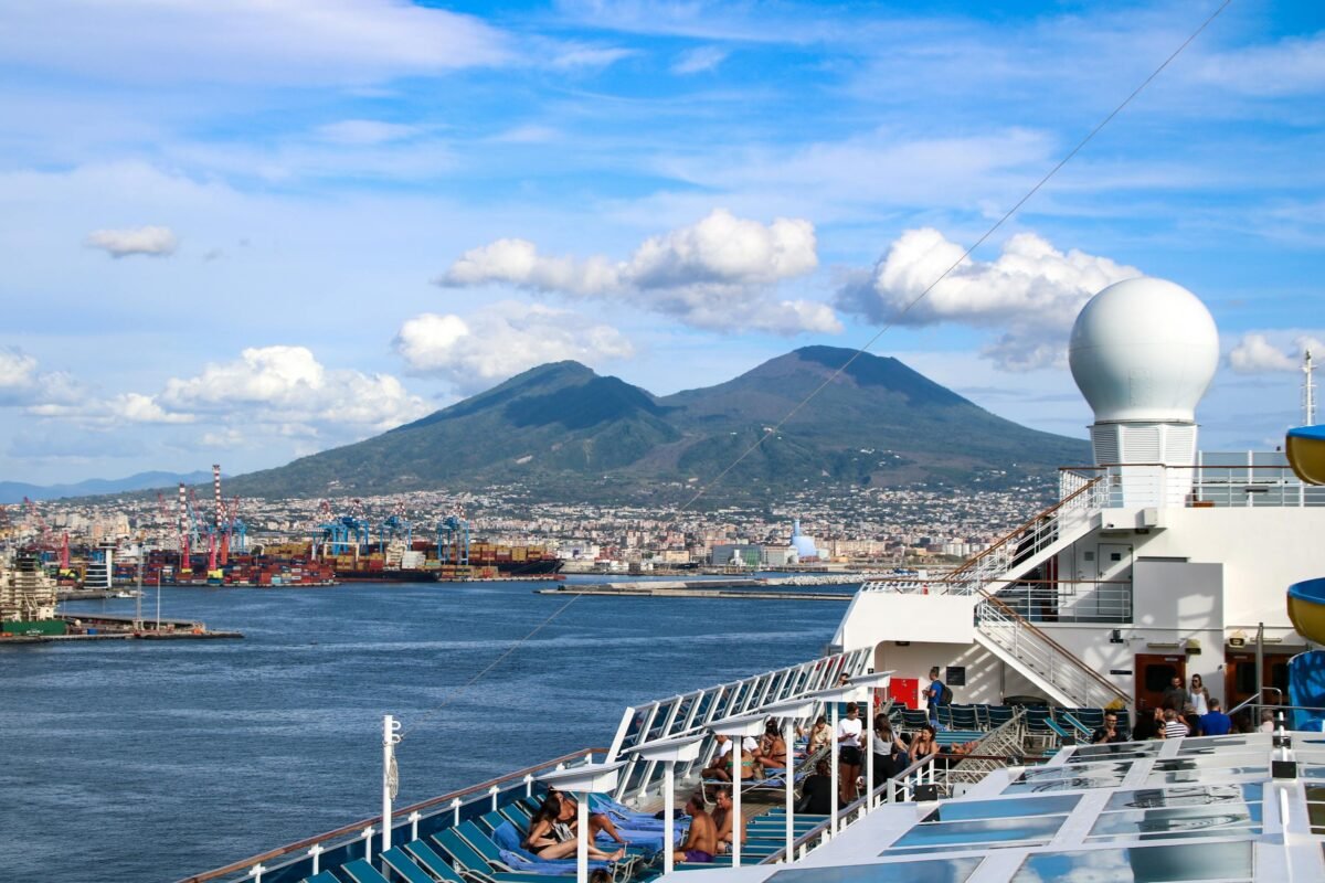 Is Naples Worth Visiting? 15 Pros and 5 Cons 2 Cruise ship deck view with Mt. Vesuvius, Naples in the background, sunny day. all makes naples worth visiting