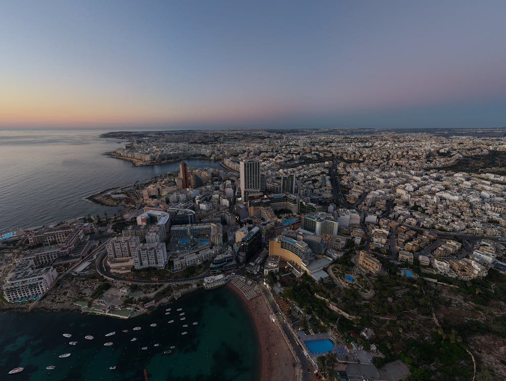 Is Malta Expensive? My Malta Budget Breakdown 2026 5 Discover a breathtaking aerial view of St. Julian’s, Malta as the sun sets, illuminating the coastline and cityscape.