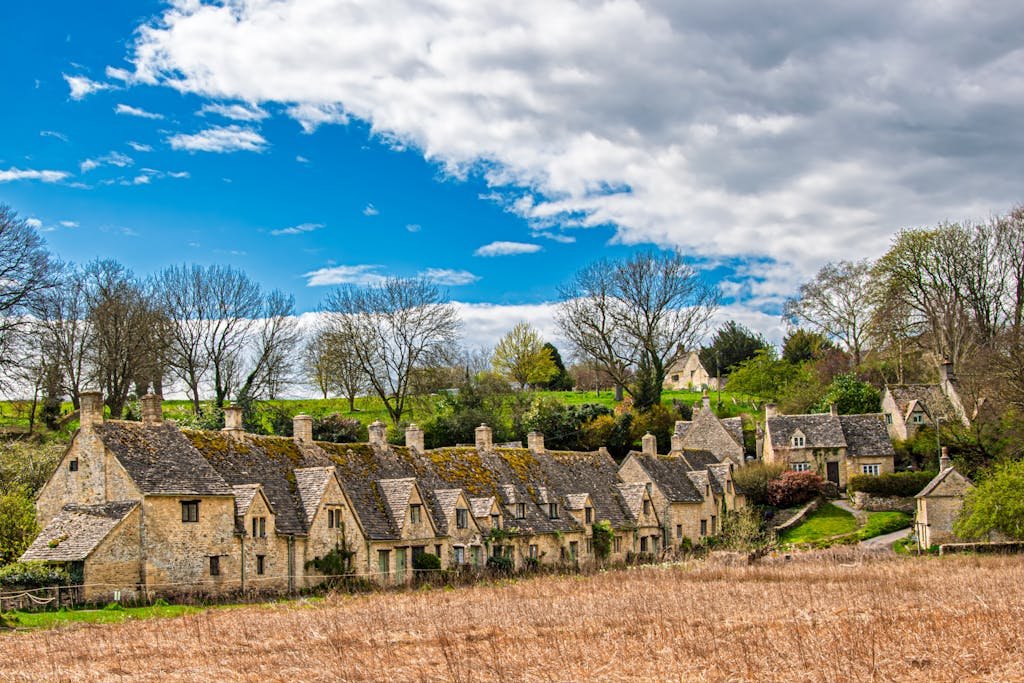 Picturesque Cotswold village with historic stone houses and vibrant spring scenery.