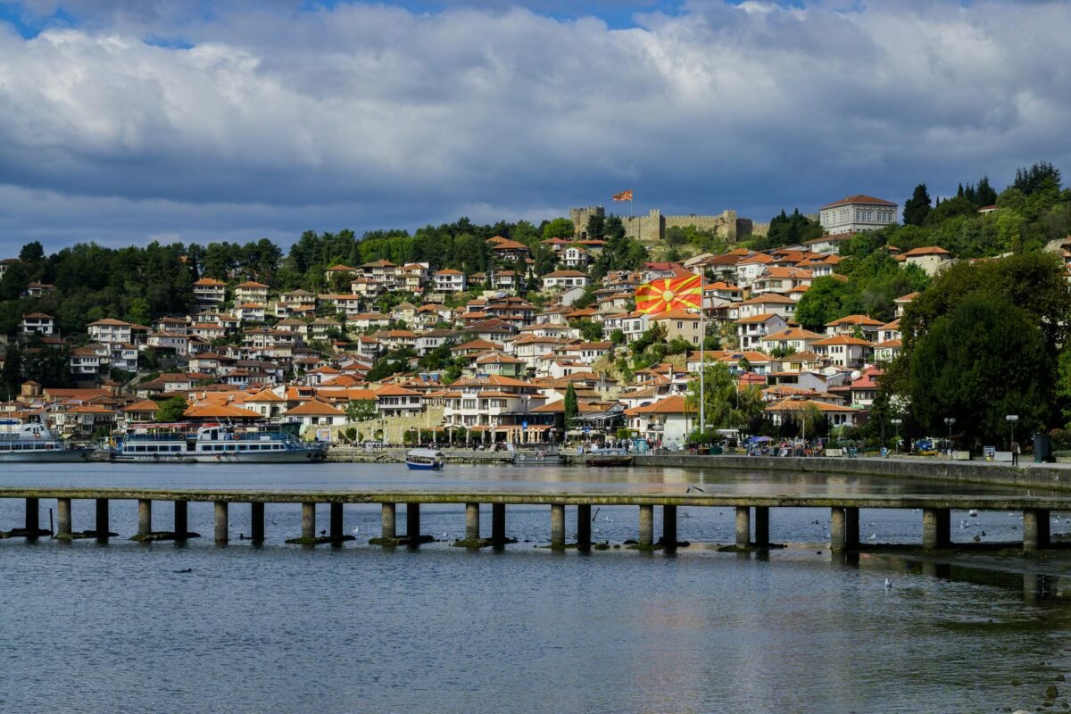 Picturesque Ohrid town with a Macedonian flag overlooking the lake and pier.