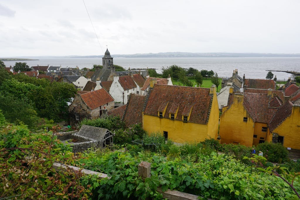 Picturesque view of Culross village in Scotland with historic buildings and the Firth of Forth.
