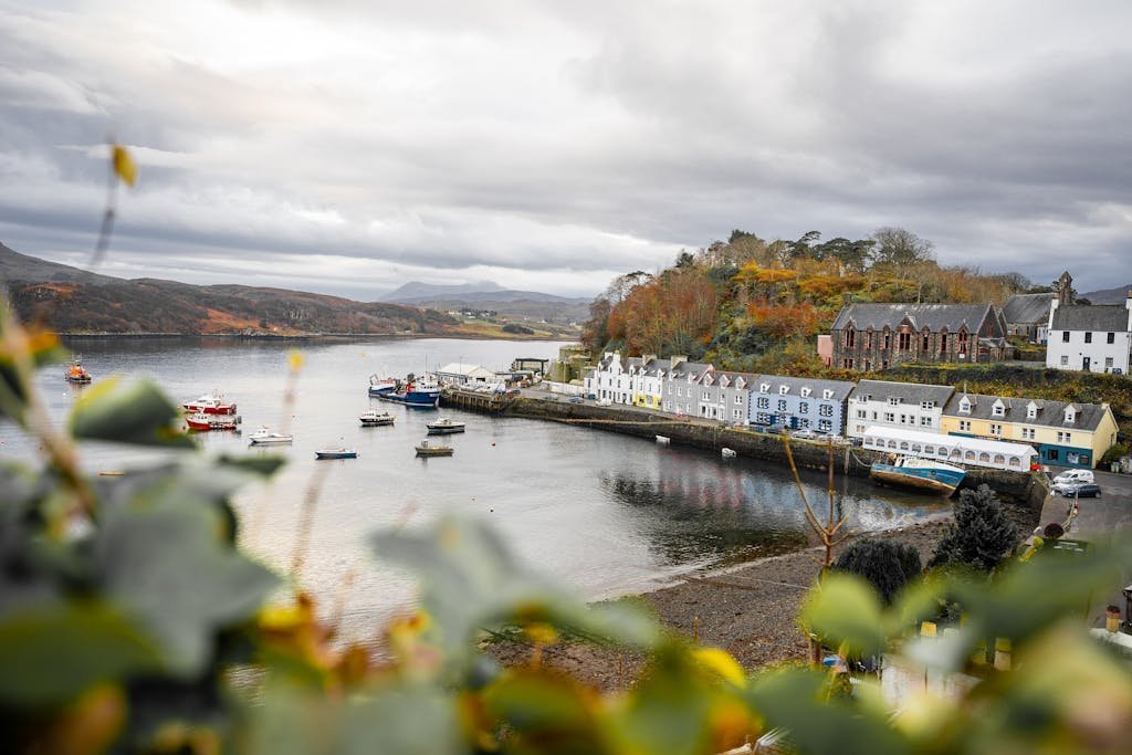 Scenic view of Portree harbor with colorful houses and boats, capturing the essence of Scottish island life.