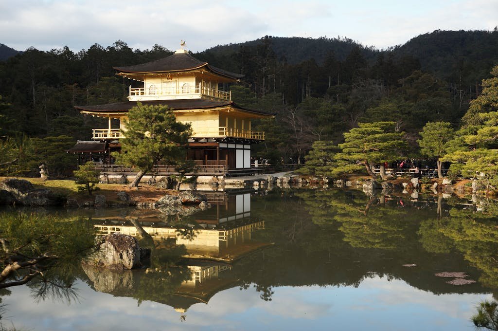 14 Best Things to Do in Kyoto, Japan + Travel Tips (2026) 11 Serene view of Kinkaku-ji Temple in Kyoto with a calm reflection in surrounding pond.