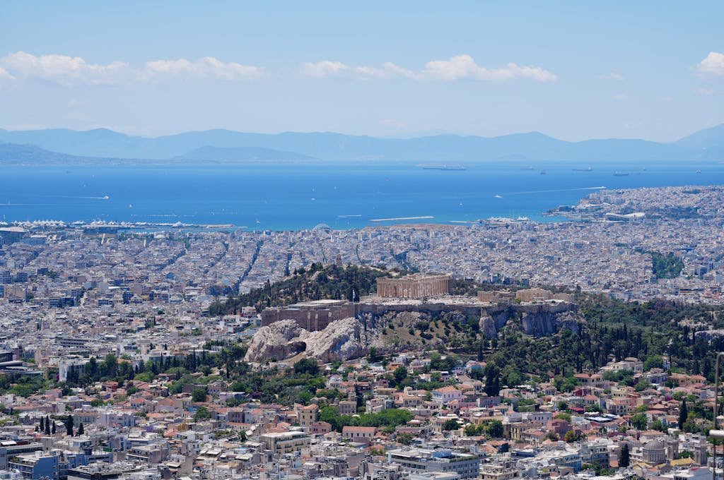 Stunning aerial panorama of Athens with the iconic Acropolis and the Aegean Sea in the background.