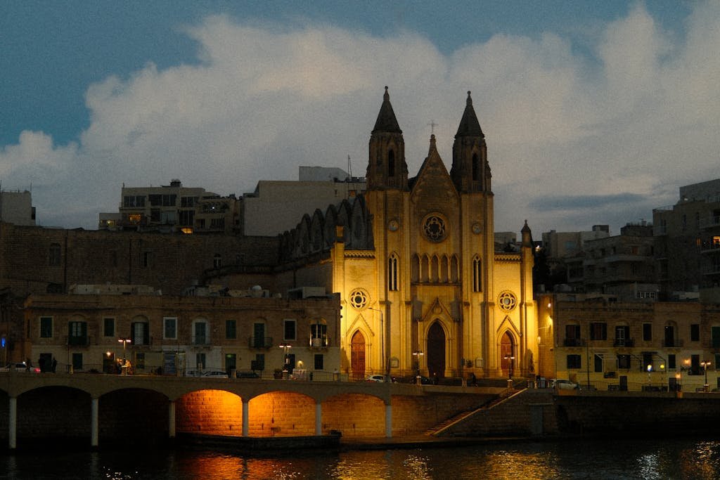 Stunning evening view of an illuminated church in Malta, showcasing its architectural beauty.