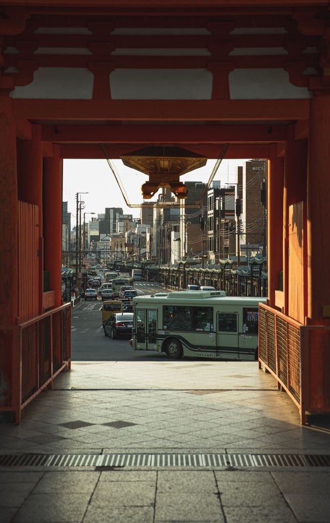 14 Best Things to Do in Kyoto, Japan + Travel Tips (2026) 17 Through red gates of ancient Yasaka Shrine of various vehicles driving on road in Kyoto district