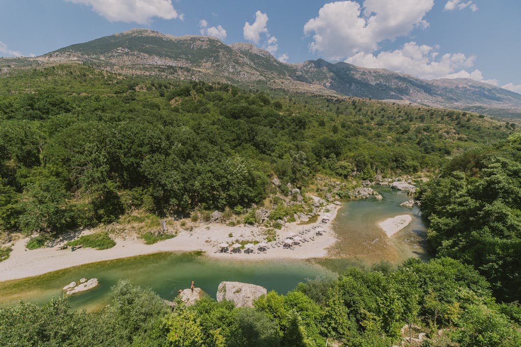 Tranquil view of a clear river and rugged mountains in Albania.