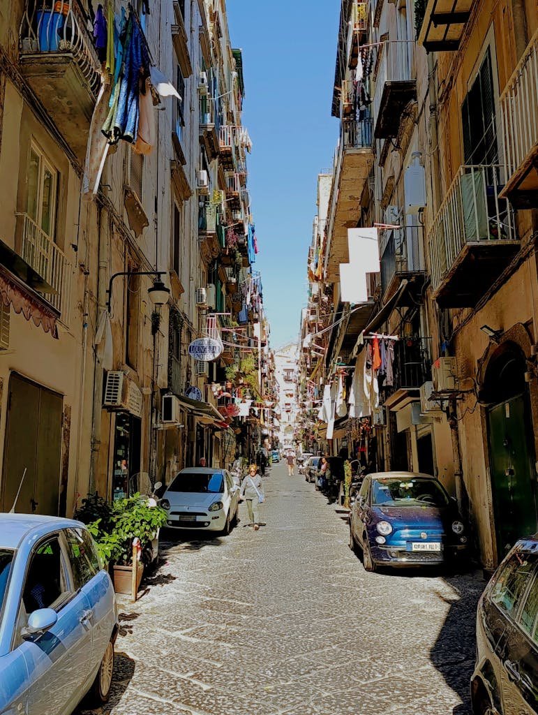 Is Naples Worth Visiting? 15 Pros and 5 Cons 4 Vibrant street scene in Napoli, Italy showcasing classic architecture and lively urban life.