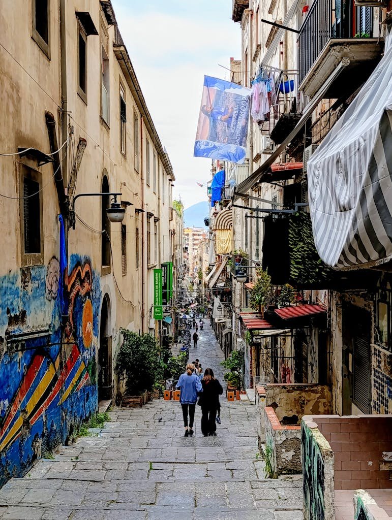 Is Naples Worth Visiting? 15 Pros and 5 Cons 12 Vibrant street scene in Napoli's Spanish Quarters showcasing local life and historic architecture.