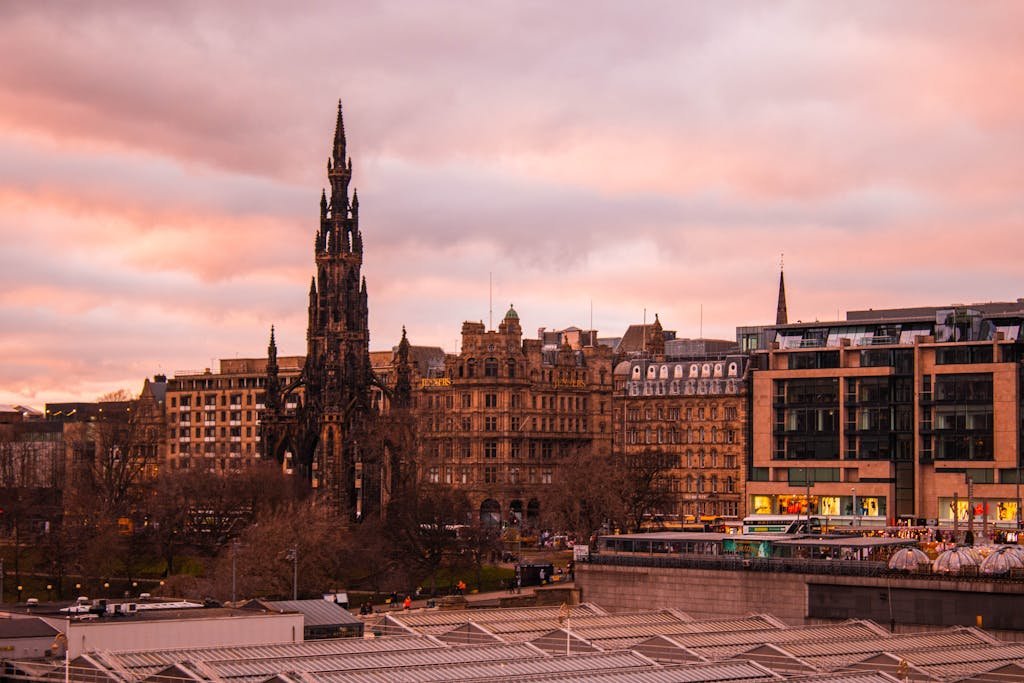 View of Scott Monument and Edinburgh skyline at sunset, offering a picturesque travel destination.
