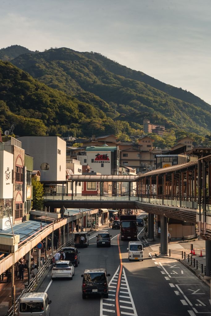 A bustling Hakone street with a view of lush mountains in Kanagawa, Japan.