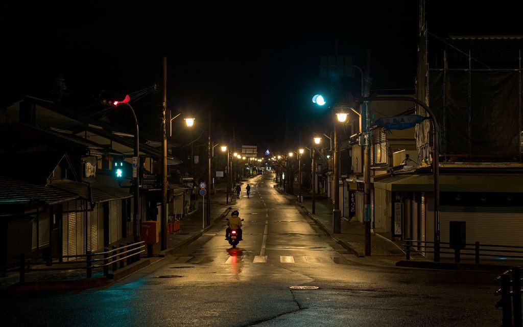 Arashiyama Bamboo Forest Kyoto: Is It Worth Visiting? 9 A tranquil night scene in Arashiyama, Kyoto, with streetlights and a lone motorbike.