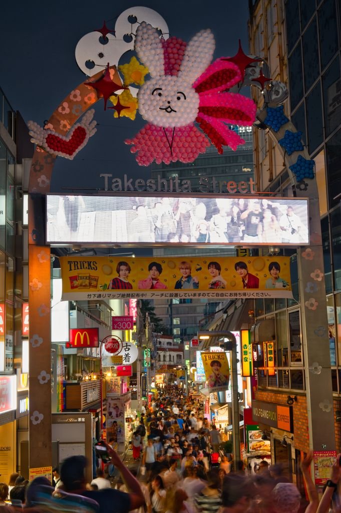 19 Best Things to Do in Shibuya, Tokyo: Food, Shopping & Tips 6 Bustling evening scene of Takeshita Street with vibrant lights and crowds in Tokyo, Japan.