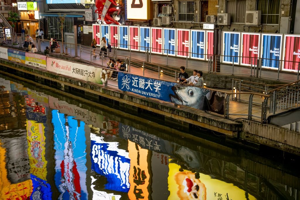 Universal Studios Japan: The Complete Guide for First-Time Visitors 3 Colorful billboards reflecting in Dotonbori canal, a lively street scene in Osaka, Japan.