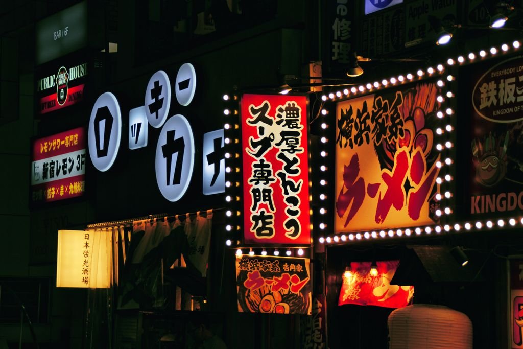 Dynamic neon signs illuminate a bustling Tokyo night market, showcasing Japanese culture.