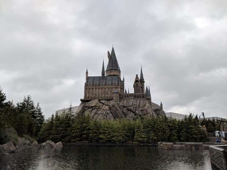 Majestic exterior view of Hogwarts Castle at Universal Studios Japan with a scenic water reflection.