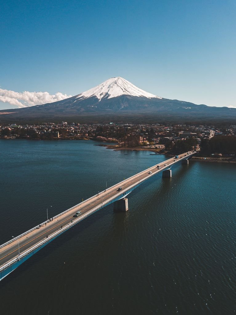 Stunning aerial view of Kawaguchiko Bridge with majestic Mount Fuji in the background.