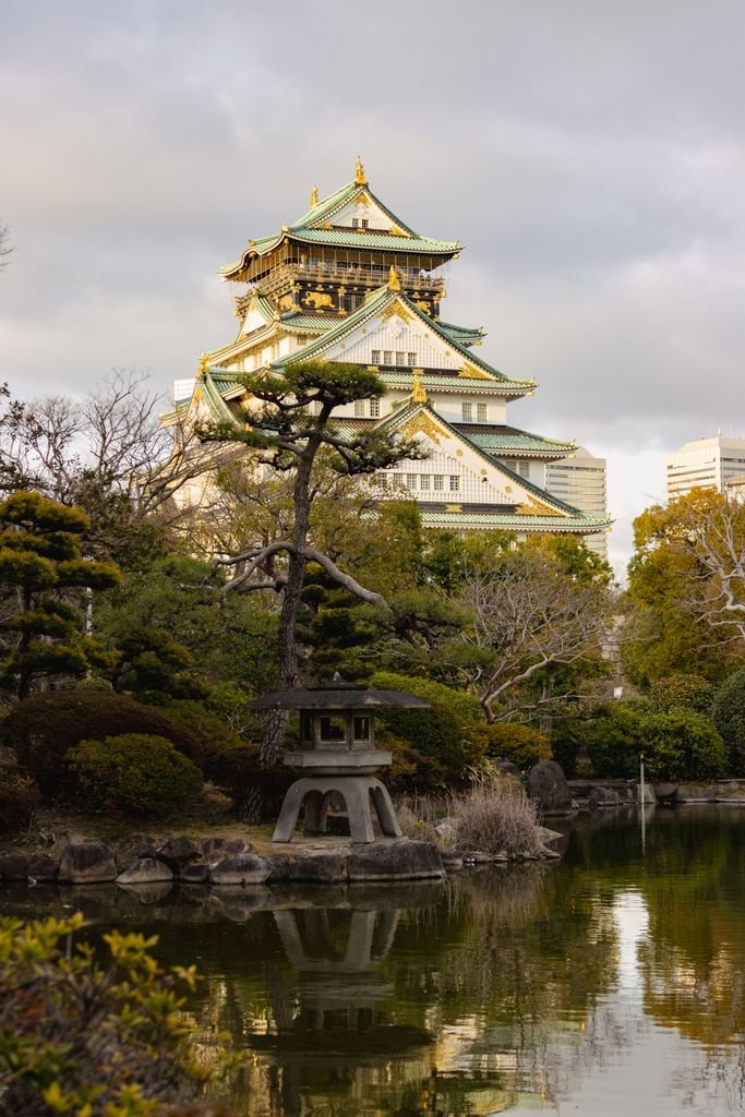 View of Osaka Castle with traditional Japanese gardens in the foreground, capturing its architectural beauty.