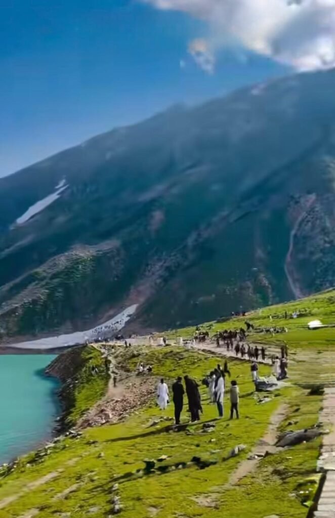 Visitors walking along the rocky shoreline of Lake Saif-ul-Malook